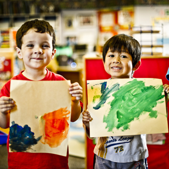 children holding up paintings