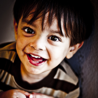 Child smiling, looking up.