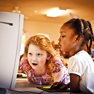 Two children at computer station