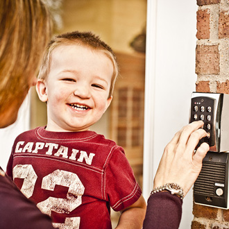 Parent entering security code with child in arms