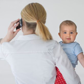 Woman in work attire holding child