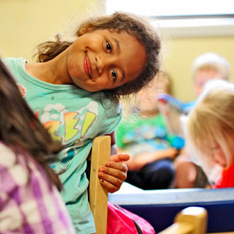 Girl leaning on chair smiling