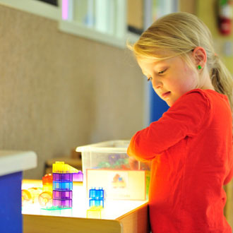 Kindergarten girl playing with blocks