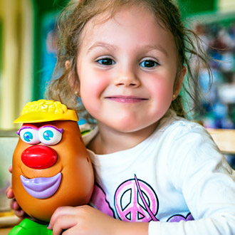 A smiling girl holding a toy