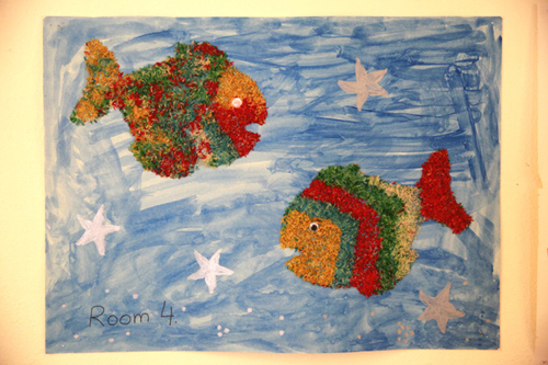 Colorful paper mache fish on a blue background with stars