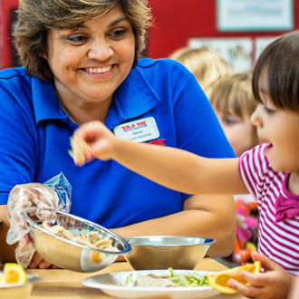 Teacher feeding children